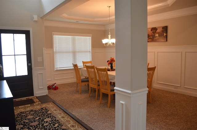 dining room featuring crown molding, a tray ceiling, dark carpet, and an inviting chandelier