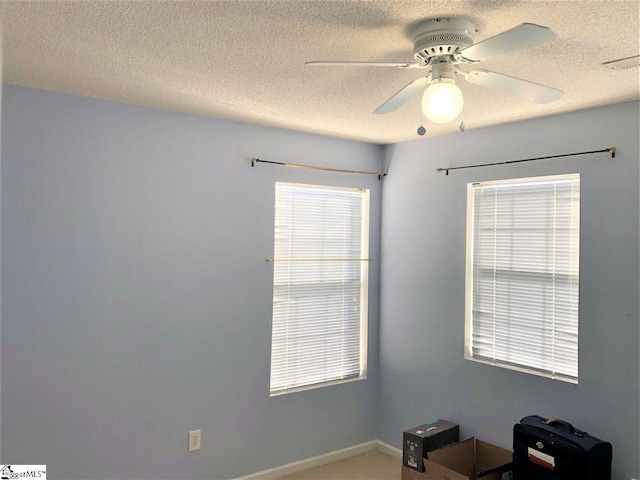 empty room featuring ceiling fan and a textured ceiling