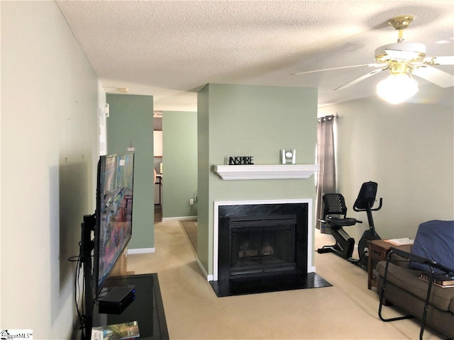 living room featuring light carpet, ceiling fan, and a textured ceiling