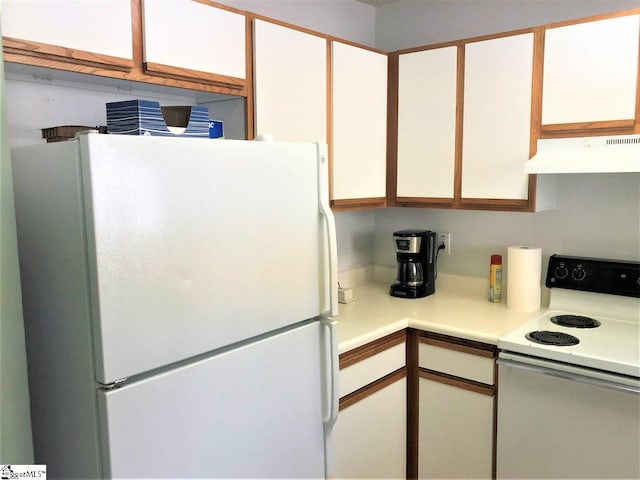 kitchen with custom range hood, white appliances, and white cabinetry