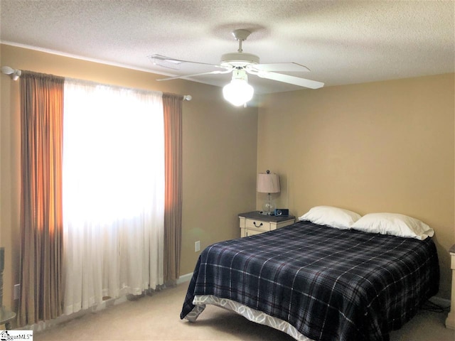 bedroom featuring ceiling fan, a textured ceiling, and light carpet