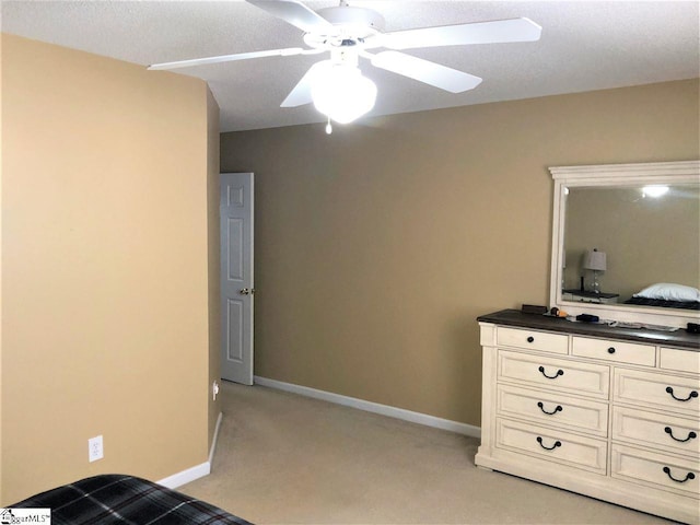 bedroom featuring light carpet, a textured ceiling, and ceiling fan