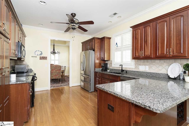 kitchen featuring ceiling fan, appliances with stainless steel finishes, light hardwood / wood-style floors, dark stone counters, and tasteful backsplash