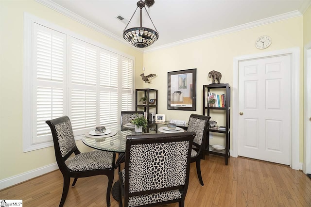 dining space featuring light hardwood / wood-style floors and ornamental molding