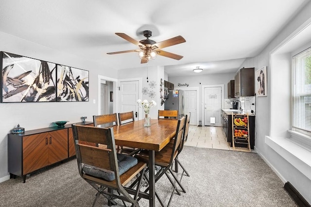 carpeted dining space featuring sink and ceiling fan