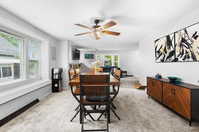 dining area with light colored carpet and ceiling fan