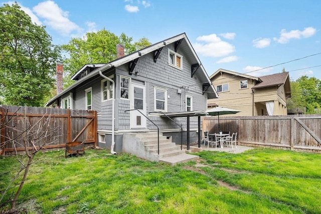 back of house with a patio area and a lawn