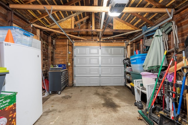 garage with white fridge and a garage door opener