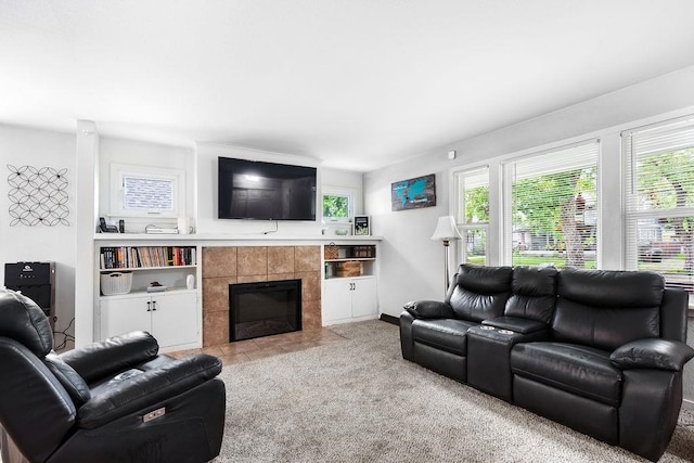 carpeted living room featuring plenty of natural light and a tile fireplace