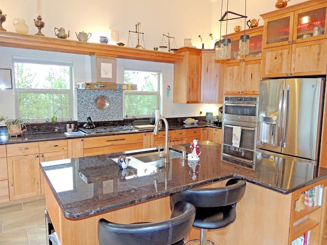 35025 Mourning Dove Ln N, Davenport, WA 99122 - kitchen with stainless steel appliances, an island with sink, a sink, dark stone counters, and glass insert cabinets