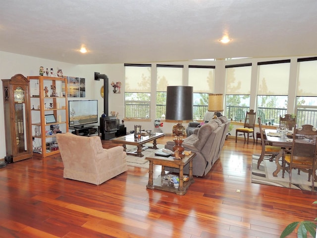 living room featuring a wood stove and wood-type flooring