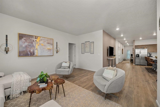 living room featuring a textured ceiling and light hardwood / wood-style flooring