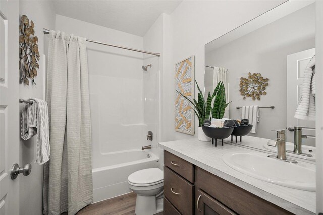 full bathroom with toilet, vanity, wood-type flooring, and shower / bath combo