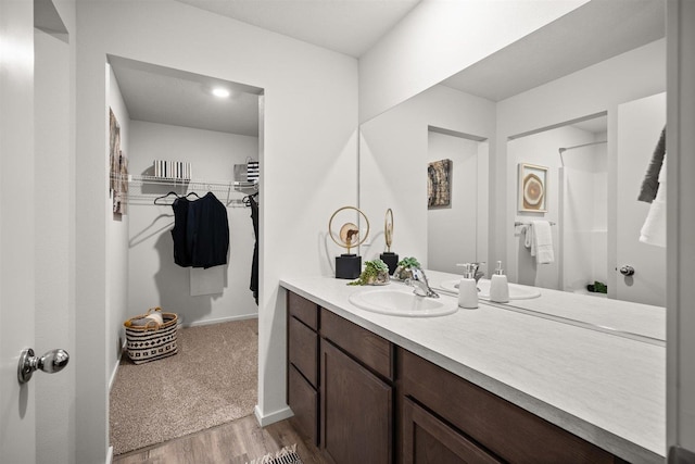 bathroom with vanity, wood-type flooring, and walk in shower