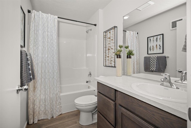 full bathroom with wood-type flooring, shower / bath combination with curtain, vanity, toilet, and a textured ceiling