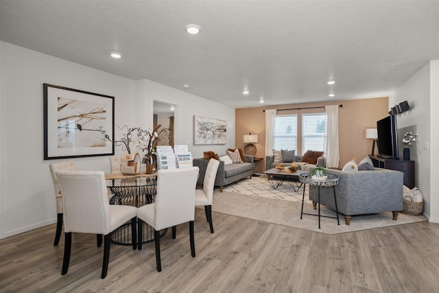 dining space featuring a textured ceiling and light hardwood / wood-style floors