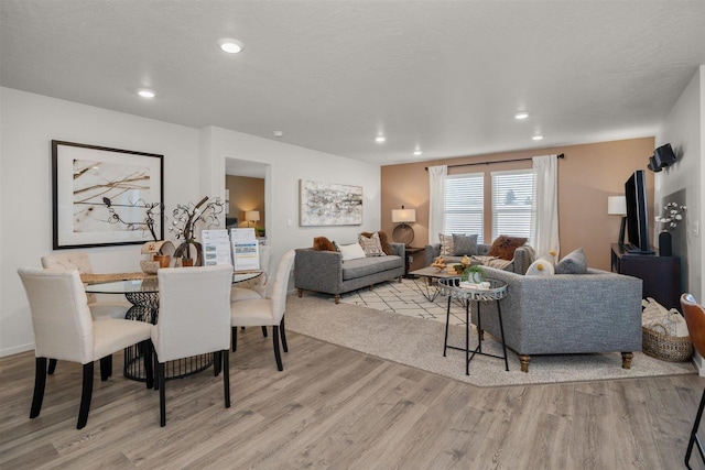 dining room with light hardwood / wood-style flooring and a textured ceiling