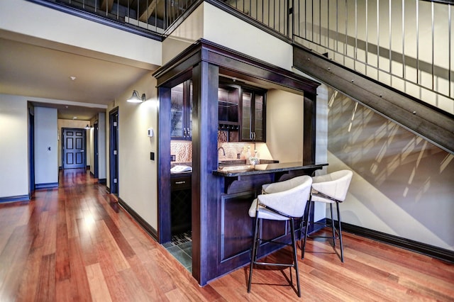 interior space with backsplash, dark hardwood / wood-style flooring, and dark brown cabinets