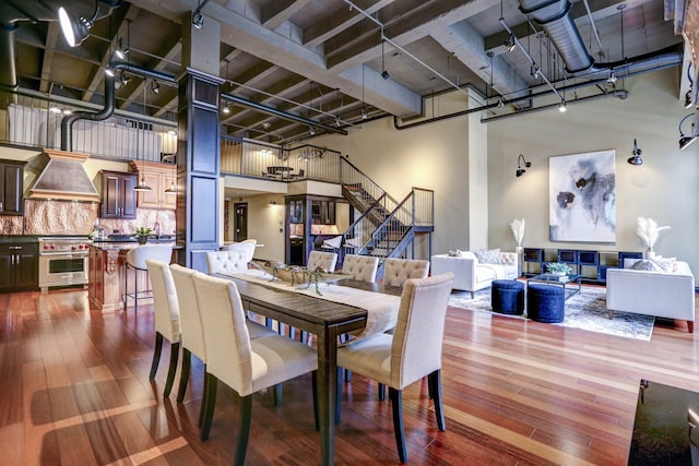 dining space with a towering ceiling and dark hardwood / wood-style floors