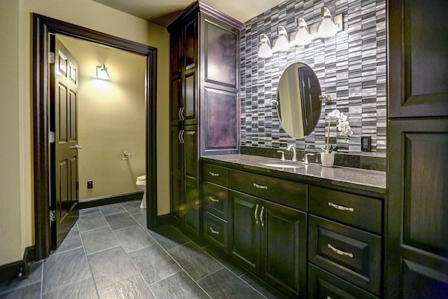 bathroom with tasteful backsplash, toilet, tile floors, and vanity