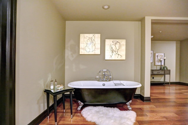 bathroom with wood-type flooring and a tub