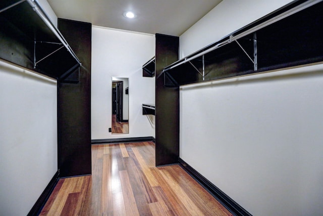 walk in closet with light hardwood / wood-style floors