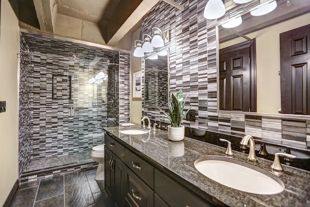 bathroom with walk in shower, vanity with extensive cabinet space, toilet, and double sink