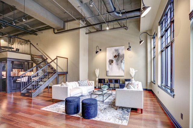 living room with dark wood-type flooring and a high ceiling