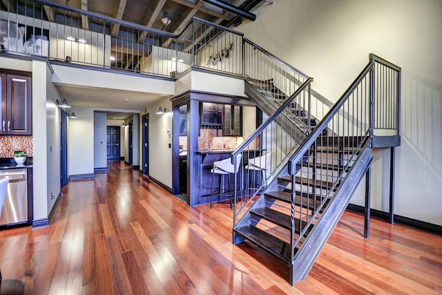 stairway featuring a high ceiling and hardwood / wood-style floors