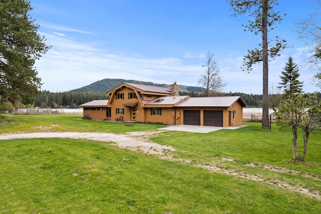 view of front of house with a mountain view, a garage, and a front lawn