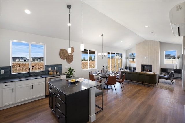 kitchen featuring sink, tasteful backsplash, white cabinetry, hanging light fixtures, and a kitchen island