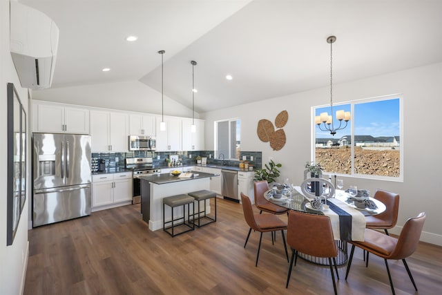 kitchen with white cabinetry, stainless steel appliances, hanging light fixtures, and decorative backsplash