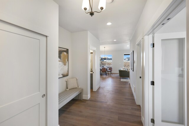 hall featuring dark hardwood / wood-style floors and a notable chandelier