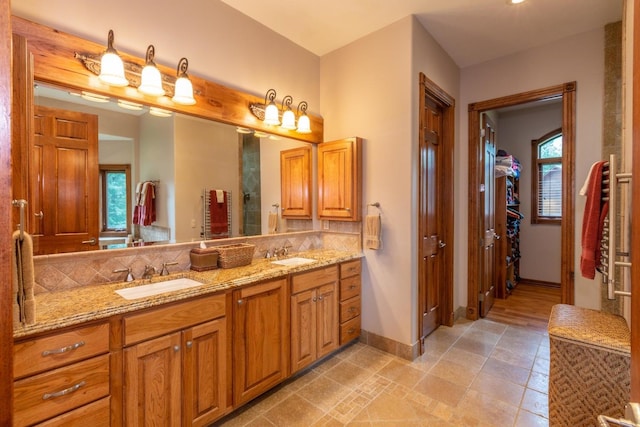 bathroom featuring tasteful backsplash, tile flooring, and dual vanity