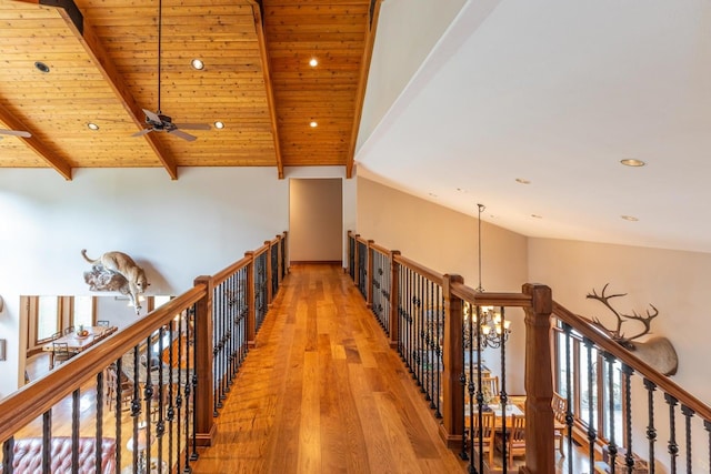 hall featuring high vaulted ceiling, beamed ceiling, hardwood / wood-style floors, wooden ceiling, and a chandelier