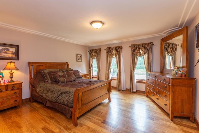 bedroom with crown molding and light hardwood / wood-style floors