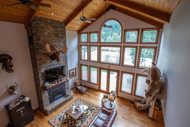 living room with a fireplace, high vaulted ceiling, light hardwood / wood-style floors, and plenty of natural light