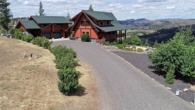 log-style house featuring a garage and a mountain view