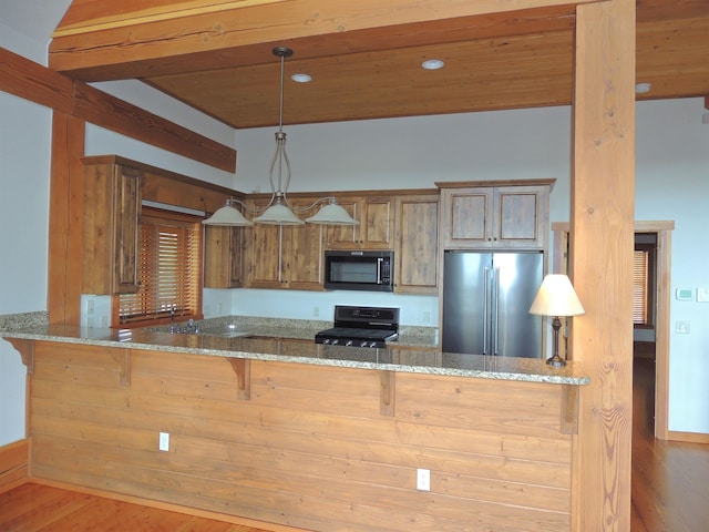 kitchen with decorative light fixtures, light stone counters, stove, wood-type flooring, and high end refrigerator