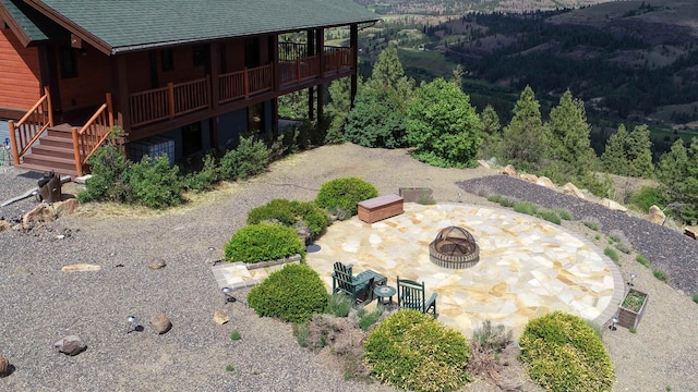 view of yard featuring an outdoor fire pit, a patio, and a wooden deck