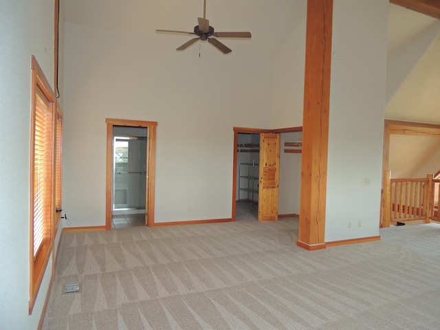 spare room featuring high vaulted ceiling, light colored carpet, plenty of natural light, and ceiling fan