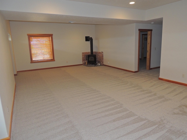 unfurnished living room with carpet and a wood stove