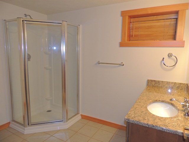 bathroom featuring tile floors, a shower with shower door, and vanity