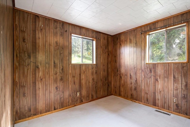 unfurnished room featuring wooden walls