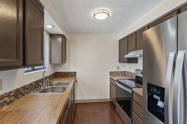 kitchen with dark hardwood / wood-style flooring, appliances with stainless steel finishes, sink, and dark brown cabinetry