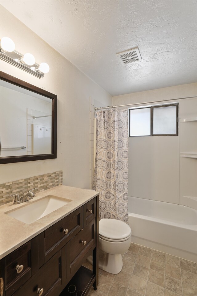 full bathroom with tasteful backsplash, a textured ceiling, shower / tub combo with curtain, toilet, and vanity