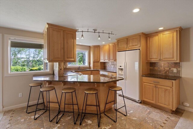 kitchen with tasteful backsplash, a breakfast bar area, and white appliances