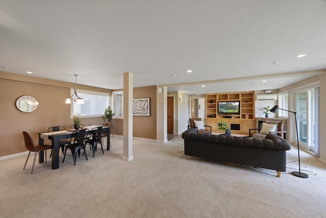 living room featuring a wall mounted air conditioner, light colored carpet, and an inviting chandelier