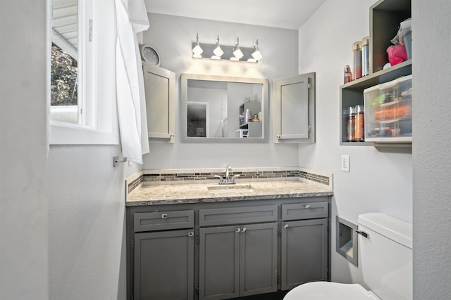 bathroom with toilet, tasteful backsplash, and vanity