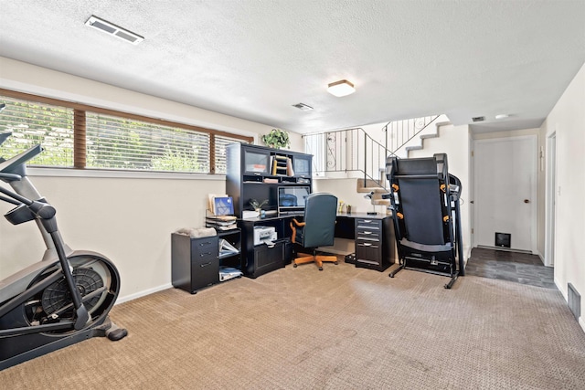 office area with light colored carpet, visible vents, a textured ceiling, and baseboards